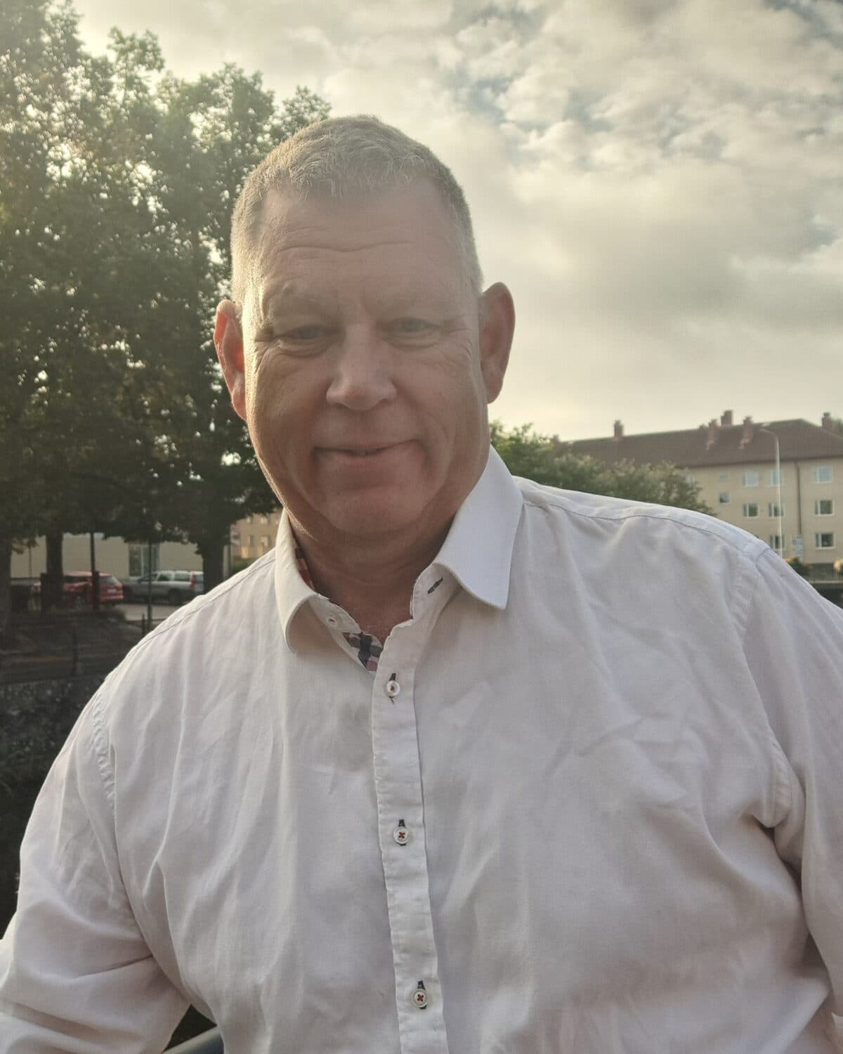 Peter utomhus i kvällsljus med träd och öppen himmel bakom sig